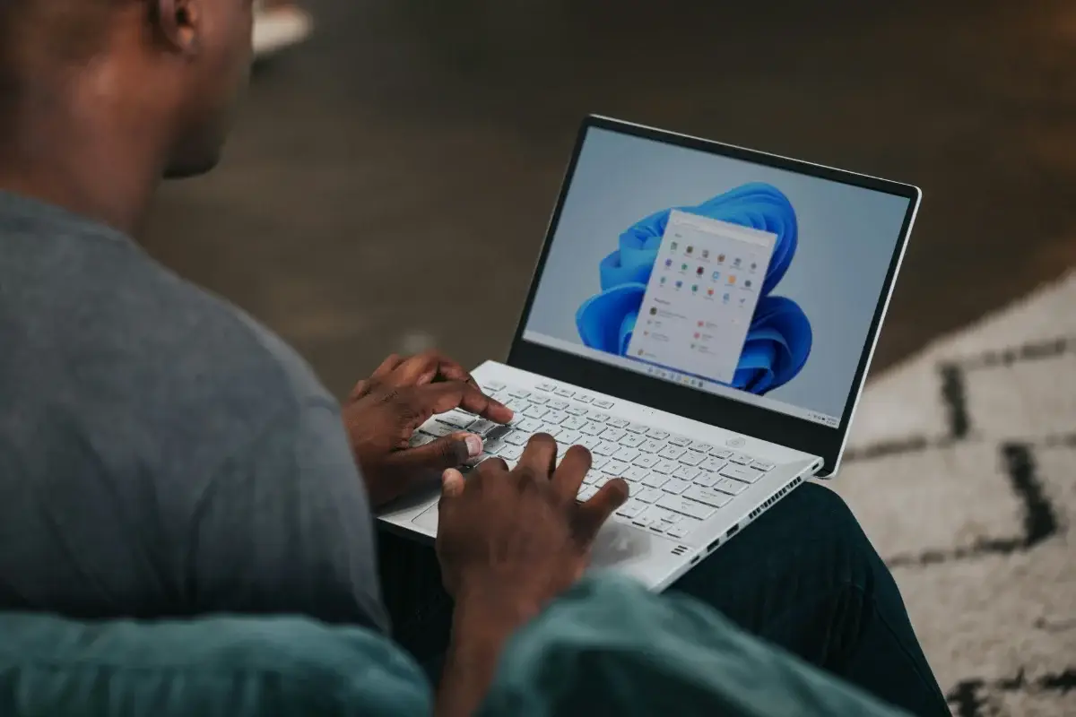 Person using a laptop running Windows 11 with the Start Menu open
